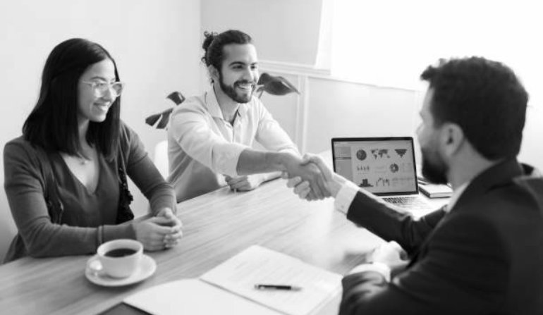 Great making business with you. Happy couple shaking hands with an agent after signing a new contract